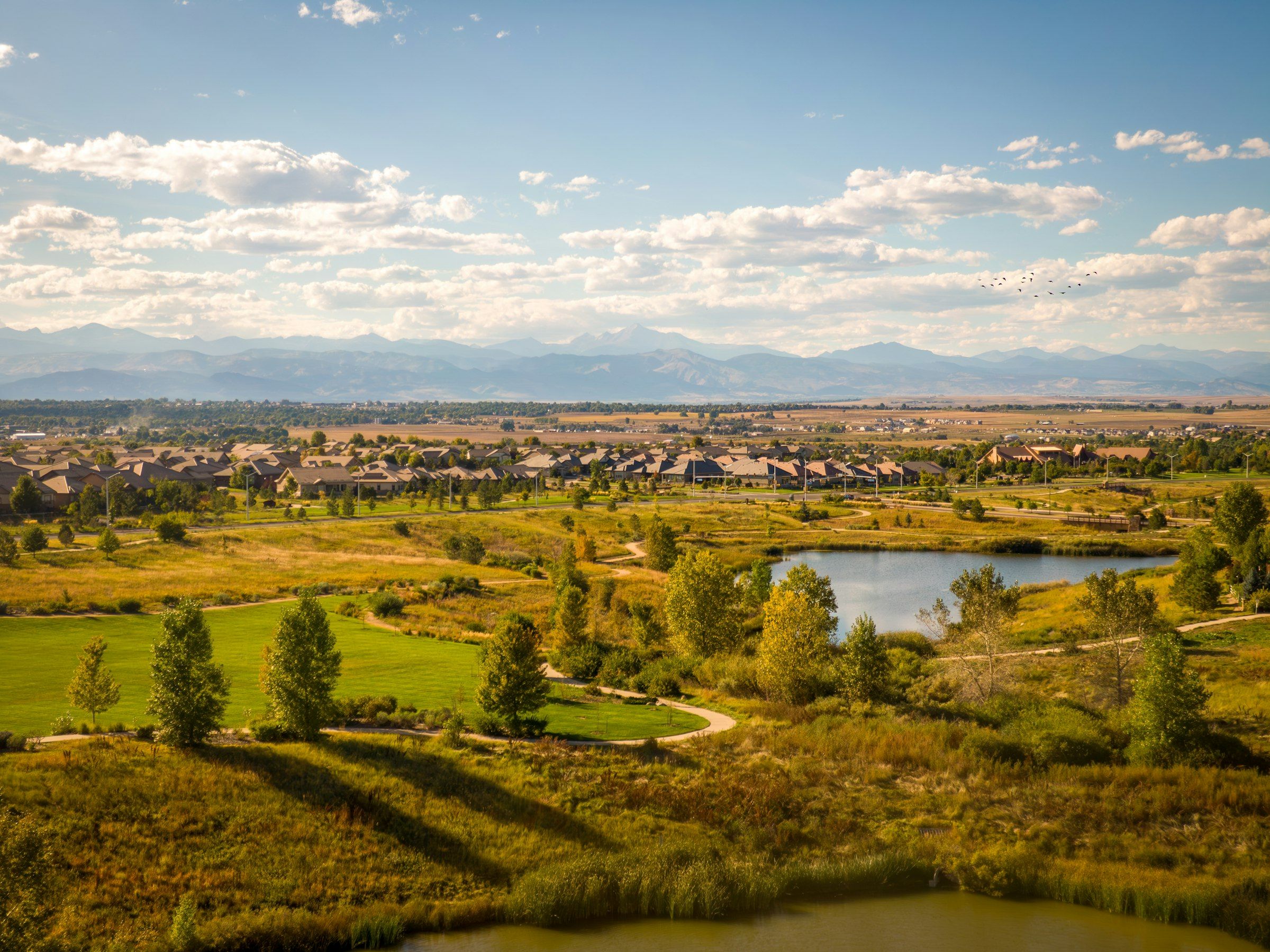 Open space and a pond in Broomfield with the Front Range in the distance