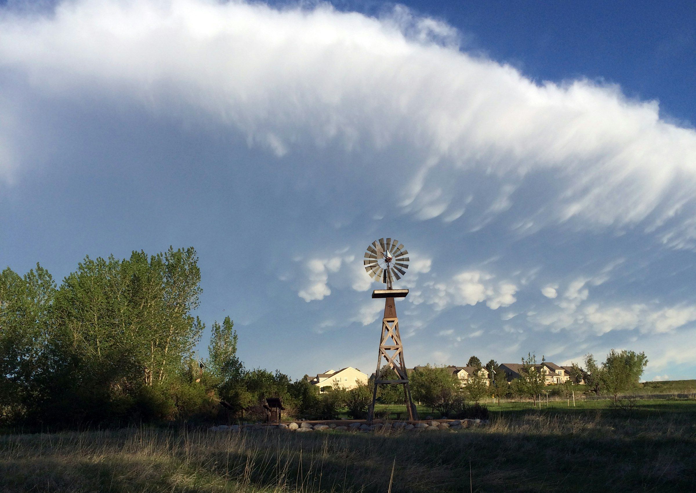 The windmill at Cheese Ranch in Highlands Ranch under a long band of cloud