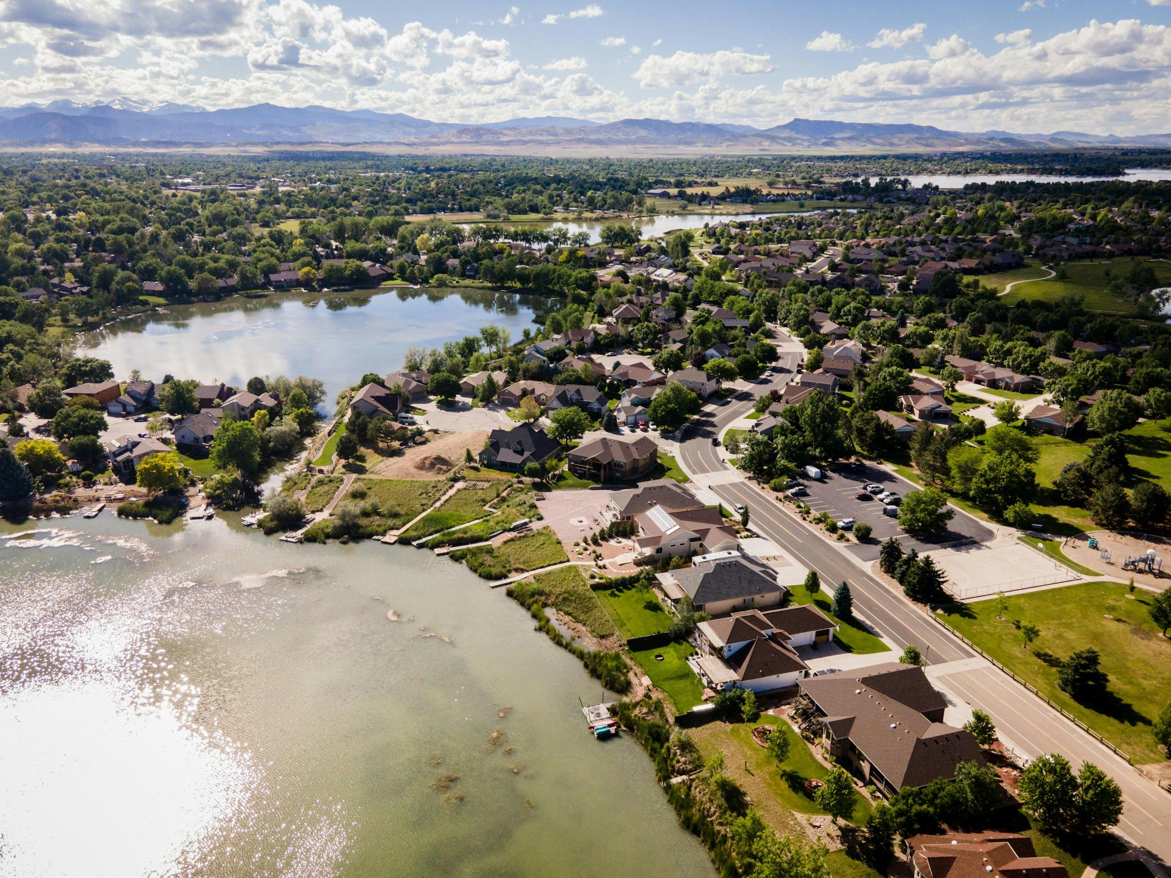 Aerial view of a lake and neighborhoods in Loveland with the foothills beyond