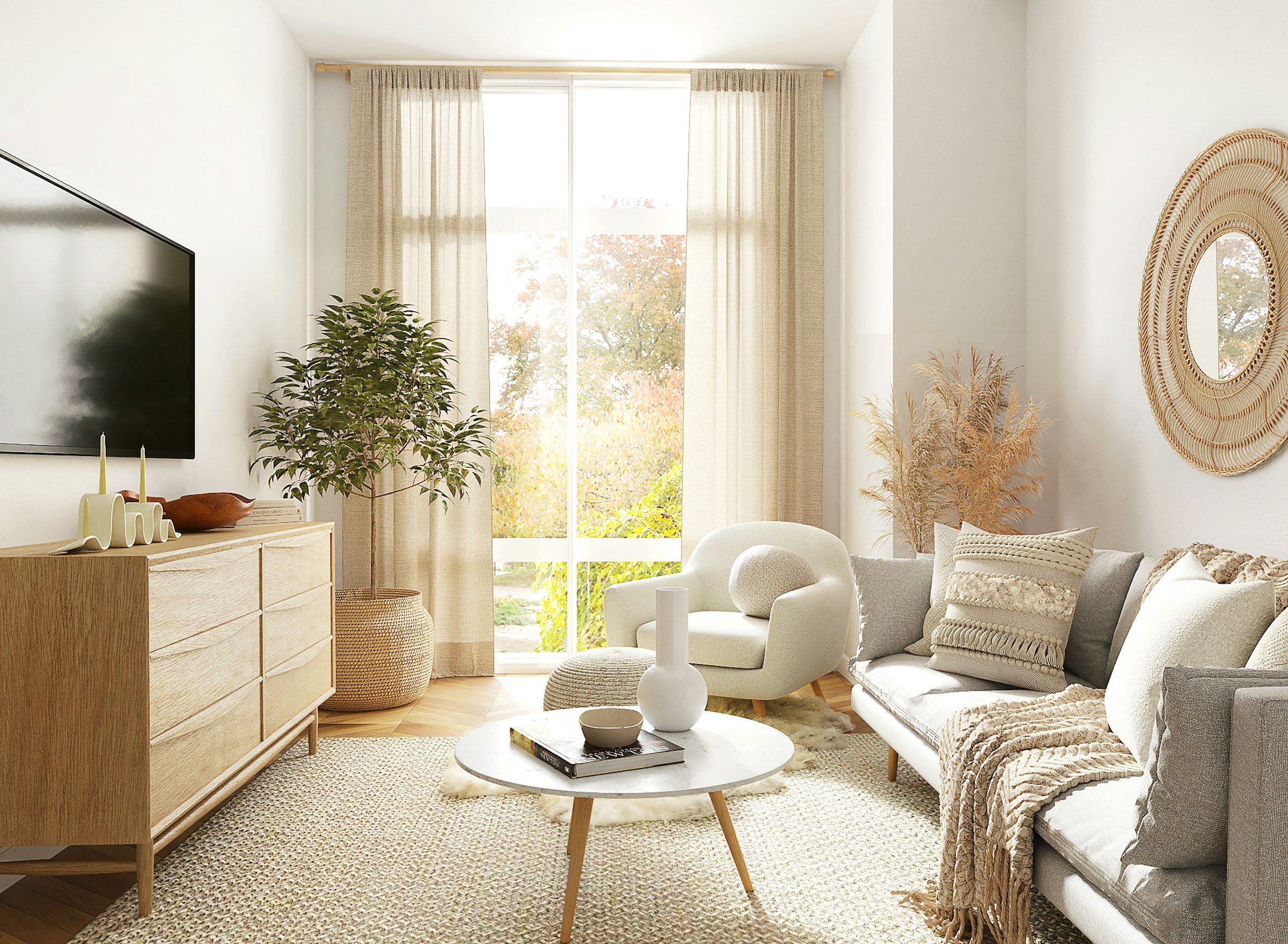 A bright living room with a sofa, a round coffee table and tall sheer curtains